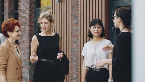 Young-Diverse-Businesswomen-Having-Discussion-on-City-Street